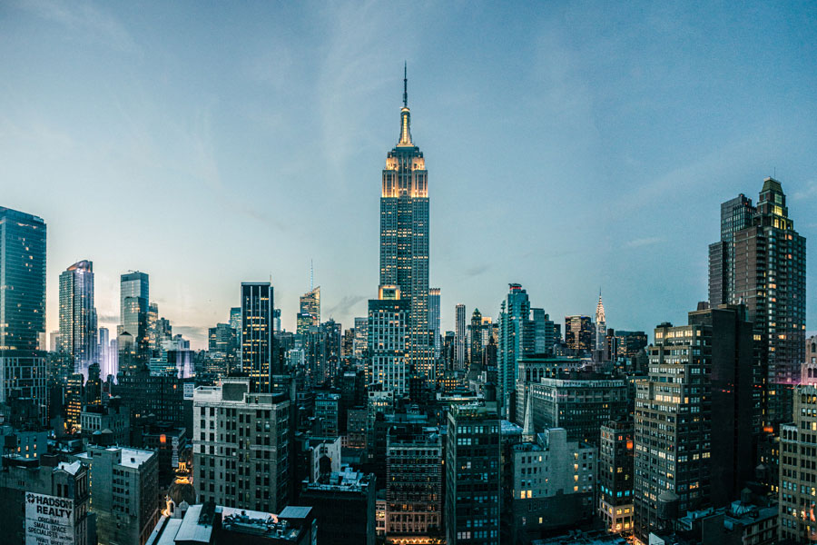 Empire State Building lit up at twilight against the New York City skyline
