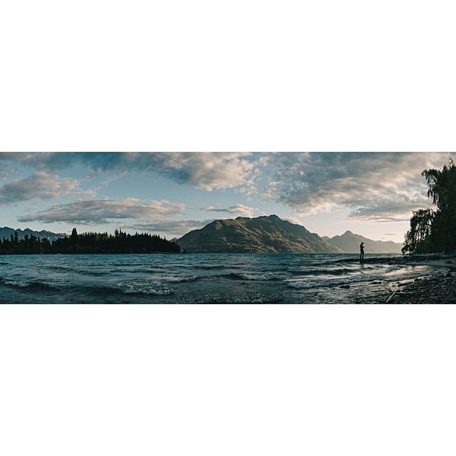 Queenstown waterfront at dusk with mountains rising behind the town