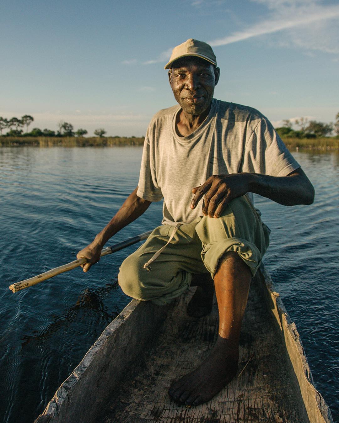 Mokoro oarsman paddling a traditional dugout canoe on the Okavango Delta, Botswana